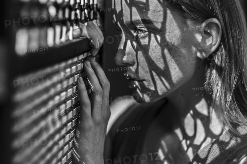Caucasian woman with freckles leaning on window