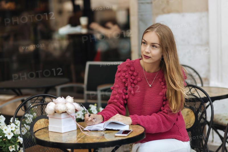 Caucasian woman sitting at table writing in journal