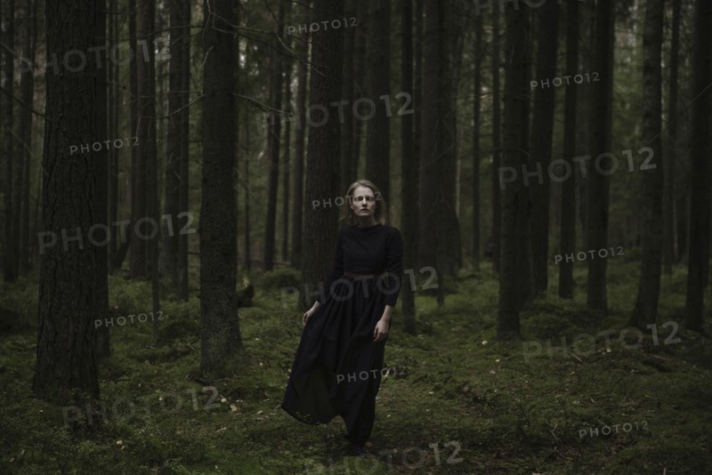 Caucasian woman standing in dark forest