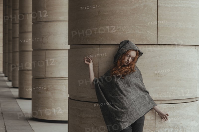 Carefree Caucasian woman leaning on pillar
