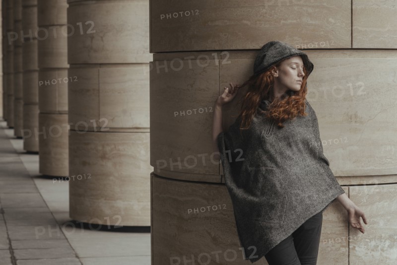 Carefree Caucasian woman leaning on pillar