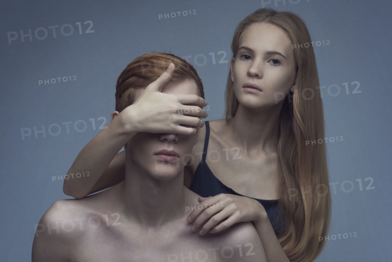 Caucasian woman covering eyes of man