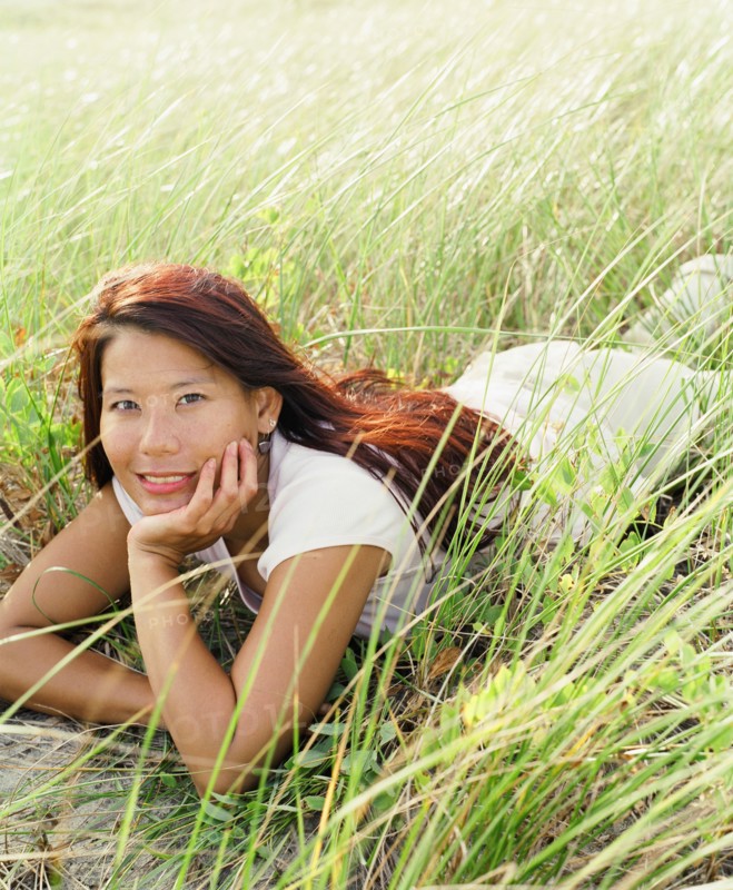 Young woman laying in sea grass