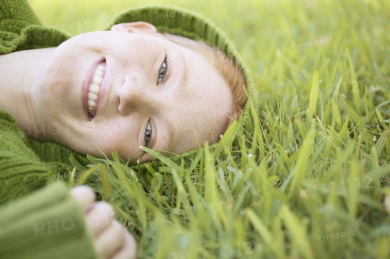 Portrait of a young woman lying on grass