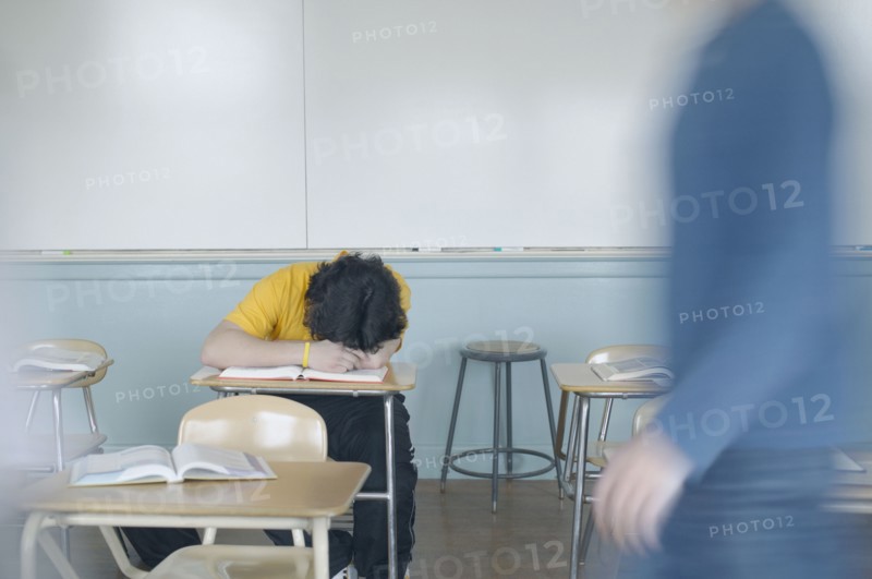 Teenage boy resting at desk