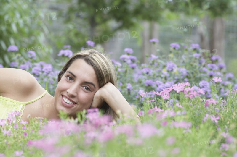 Portrait of young woman lying on grass