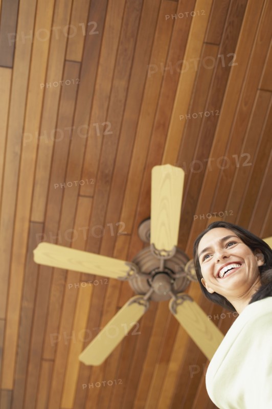 Woman standing under ceiling fan