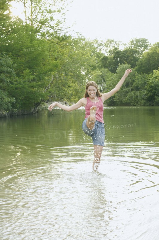 Young woman splashing water