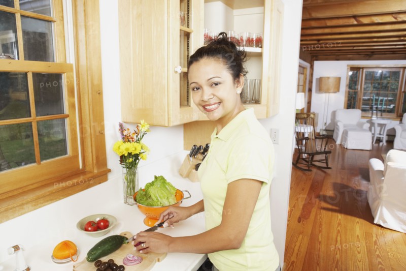 Young woman chopping vegetables in the kitchen