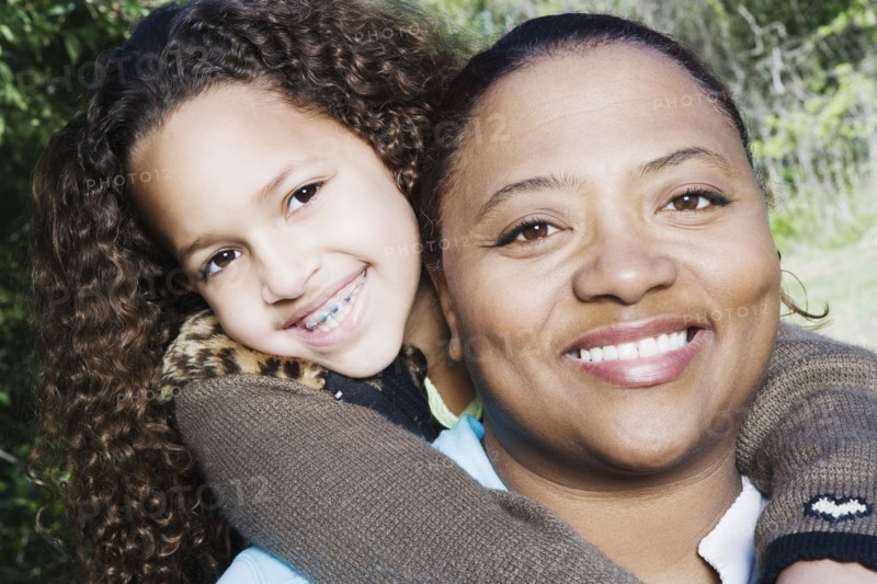 African mother and daughter hugging outdoors