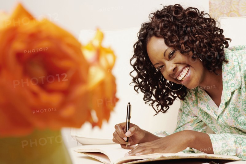 African woman writing in book