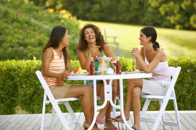 Three women eating on patio