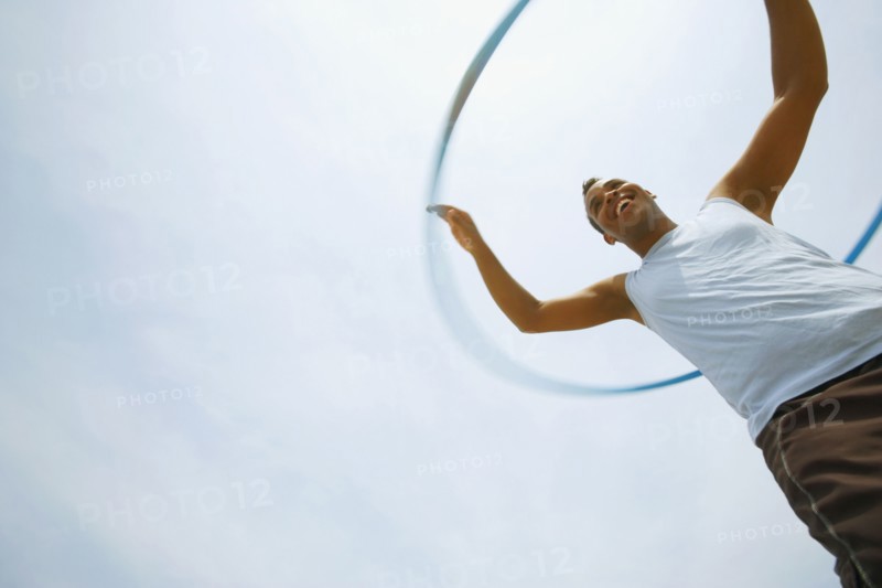 Hispanic man playing with plastic hoop
