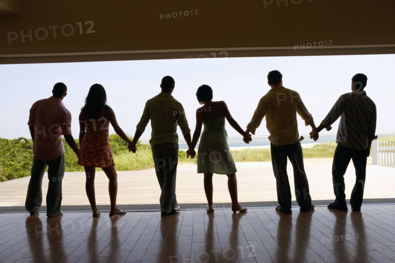 Silhouette of friends holding hands at beach resort