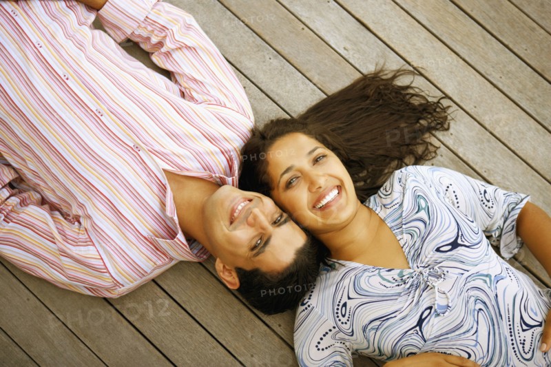 Young couple laying on deck
