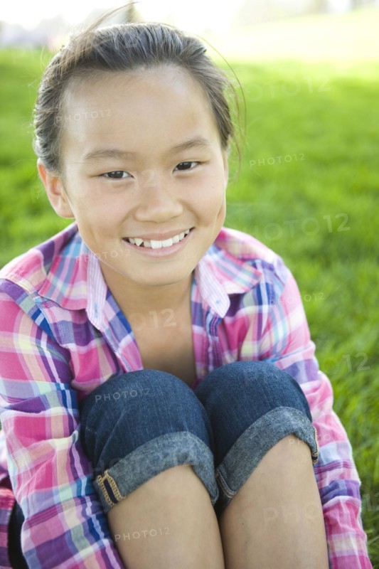 Smiling Chinese girl sitting in grass