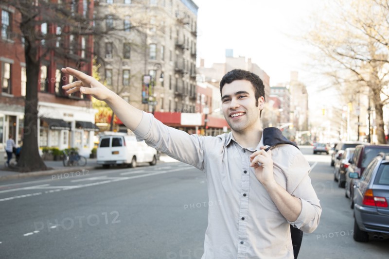 Hispanic man hailing taxi on city street