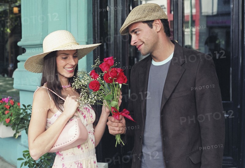 Hispanic man giving flowers to girlfriend