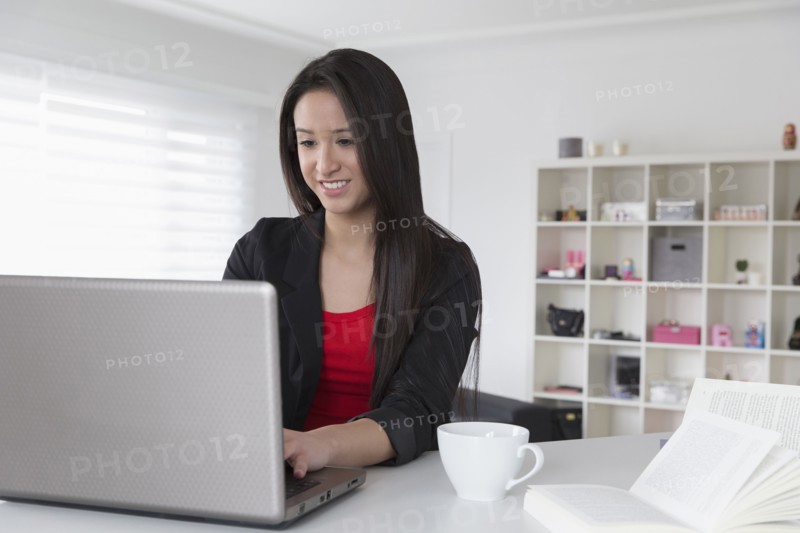 Mixed race businesswoman using laptop