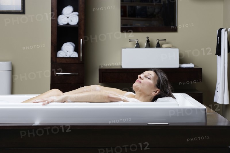 Caucasian woman relaxing in bubble bath