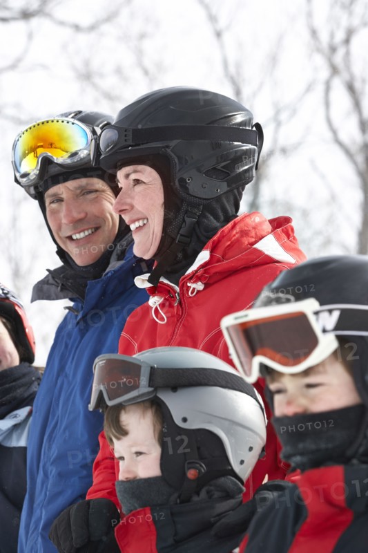 Caucasian family wearing ski gear in snow