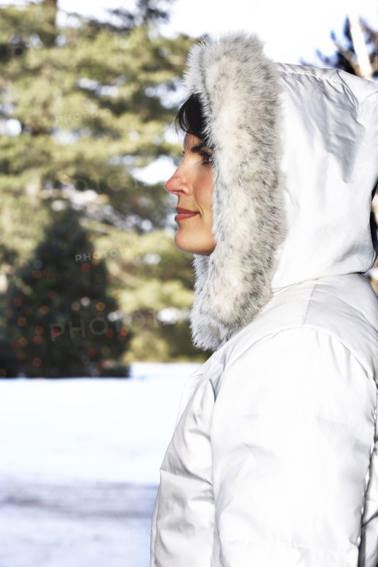 Caucasian woman wearing fur hood in snow