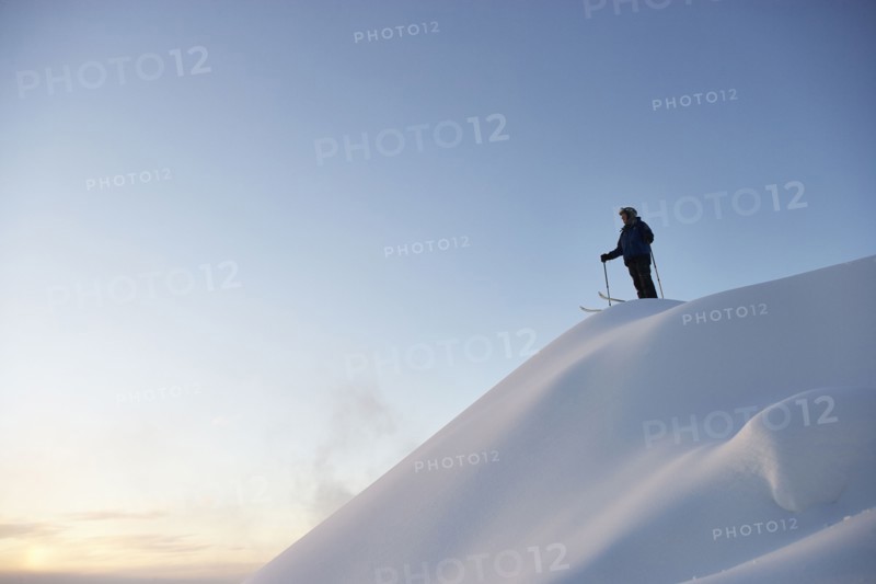 Caucasian skier standing on snowy hilltop