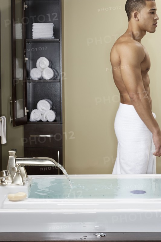 Mixed race man running bath