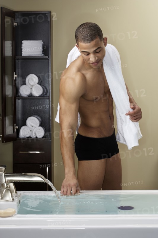 Mixed race man running bath