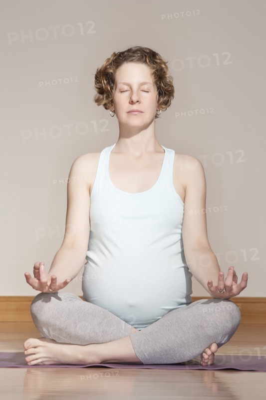 Caucasian pregnant woman meditating