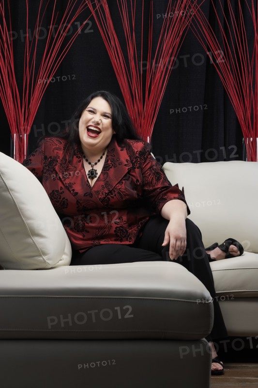 Caucasian woman laughing on sofa