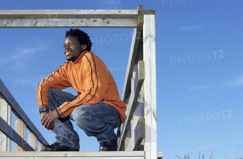 Black man on wooden dock outdoors
