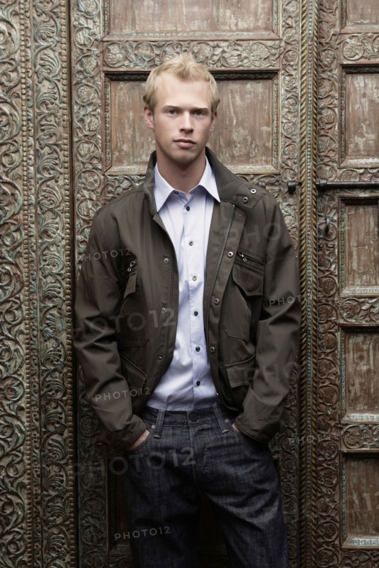 Caucasian man standing at ornate door