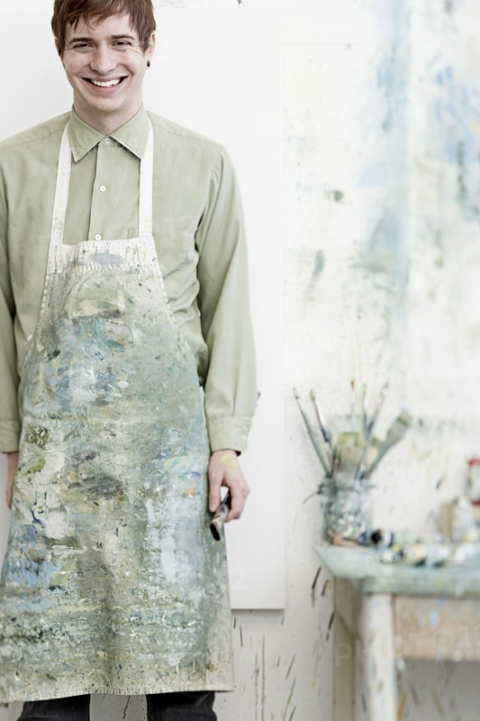 Caucasian artist smiling in studio