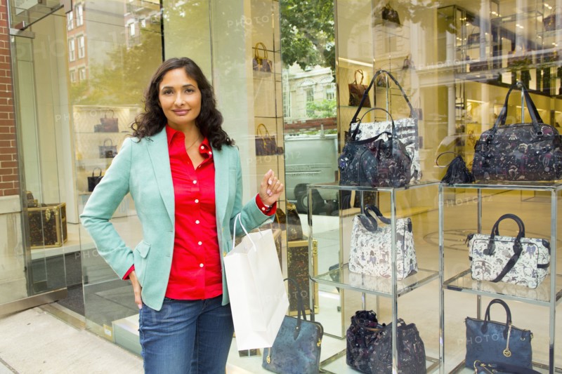 Mixed race woman window shopping at purse shop