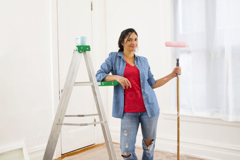 Mixed race woman painting room