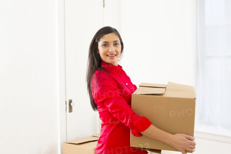 Mixed race woman carrying cardboard box