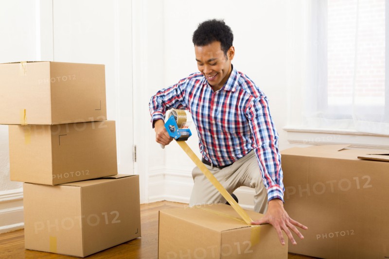 Mixed race man packing cardboard boxes