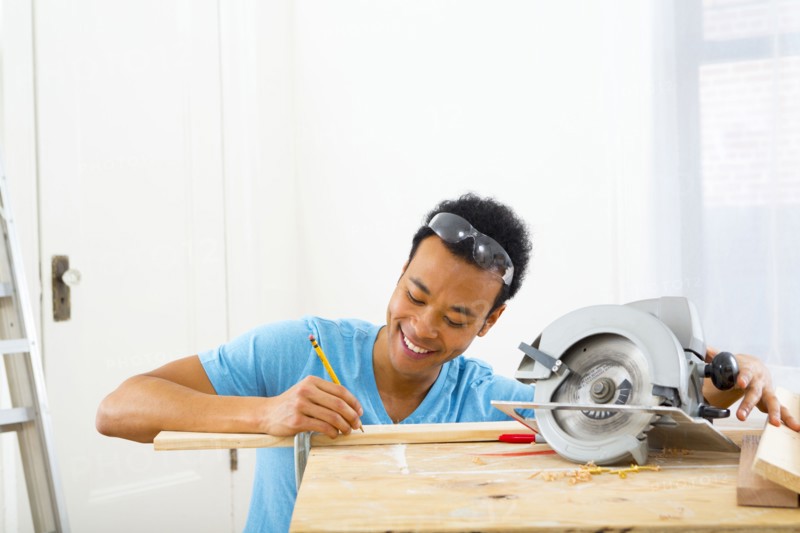 Mixed race carpenter marking wood