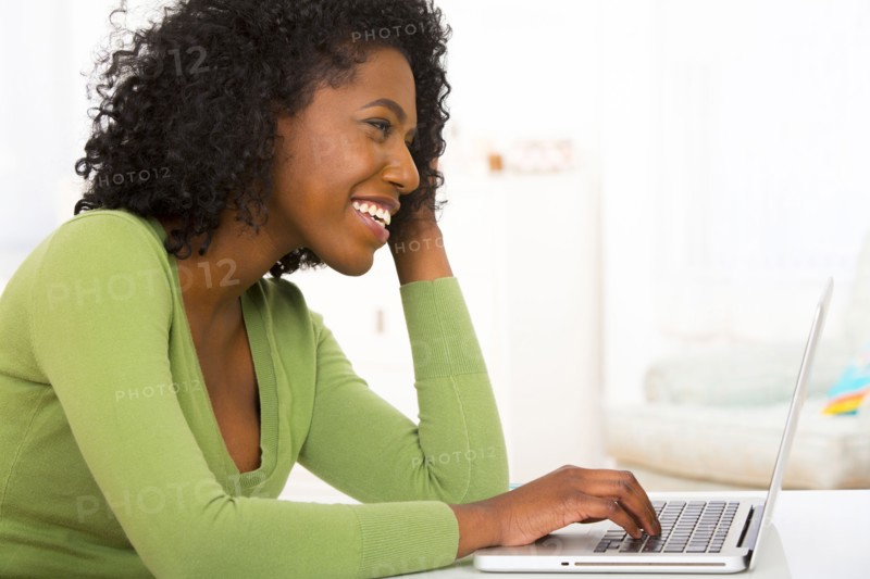 Mixed race woman using laptop at desk