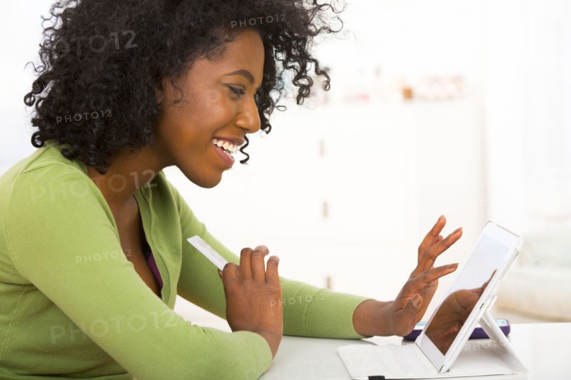Mixed race woman using tablet computer at desk