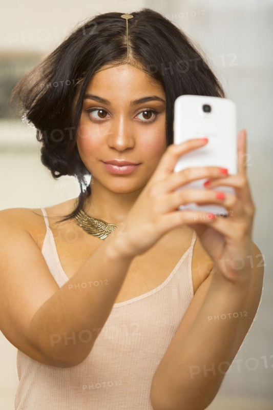 Hispanic woman taking picture of herself