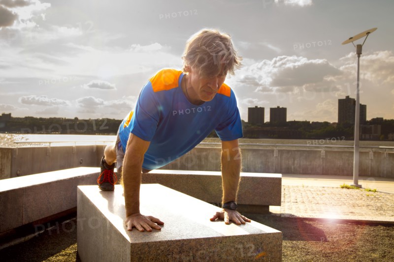 Caucasian man doing push ups in urban park