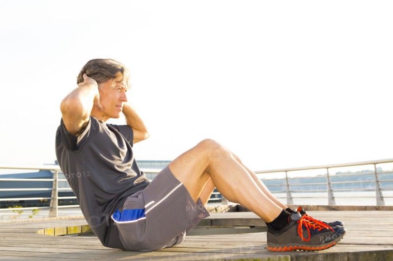 Caucasian man stretching in waterfront park