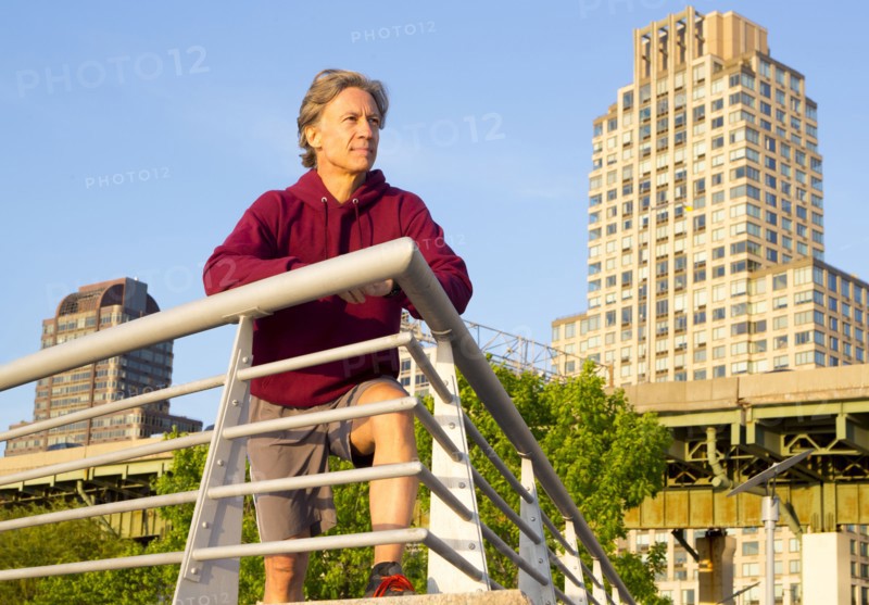 Caucasian man leaning on railing in urban park