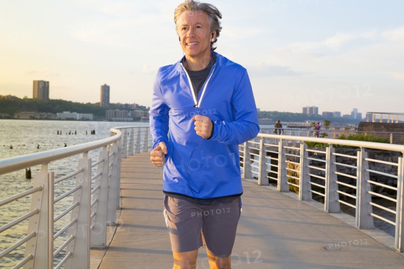Caucasian man jogging on urban waterfront