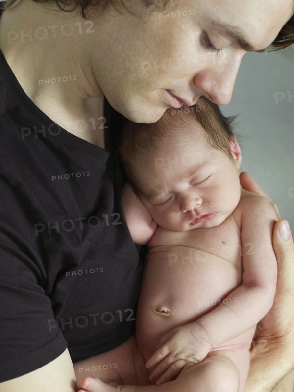 Father cuddling newborn baby