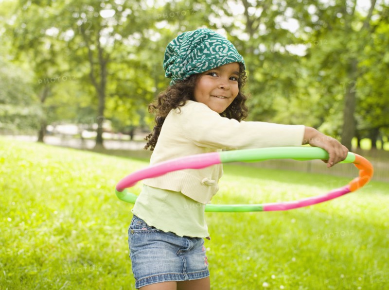 Mixed race girl playing with plastic hoop