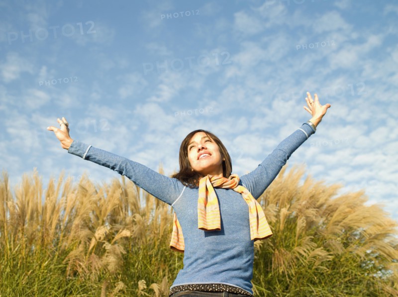 Mixed race woman with arms outstretched outdoors