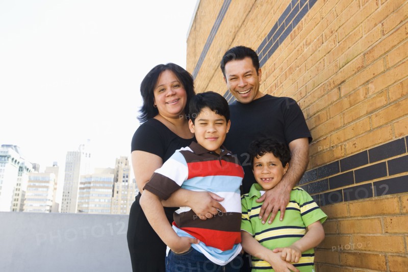 Hispanic family hugging outdoors
